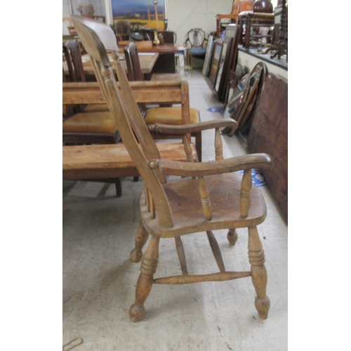 283 - A 19thC Windsor beech and elm framed, lath back, open arm chair, the solid seat raised on turned leg... 