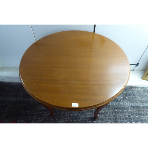 30 - A modern teak centre table, raised on slender cabriole legs  30