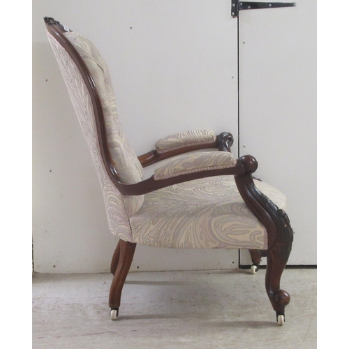 326 - A mid Victorian carved and moulded, showwood framed mahogany waisted spoonback chair with open arms,... 