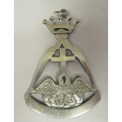 333 - A paste set white metal, hinged pendant, featuring a crown, over a cross and swan with spreading win... 