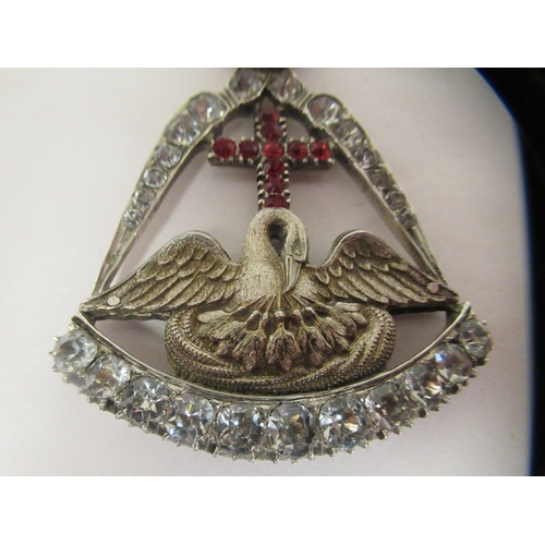 333 - A paste set white metal, hinged pendant, featuring a crown, over a cross and swan with spreading win... 