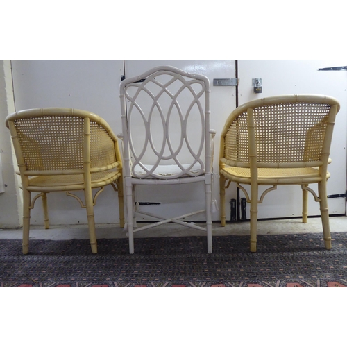 34 - A pair of simulated bamboo, cream wash painted, caned, framed chairs; and another dissimilar