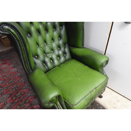 43 - A modern wingback armchair, stud and part button upholstered in green hide, raised on cabriole forel... 