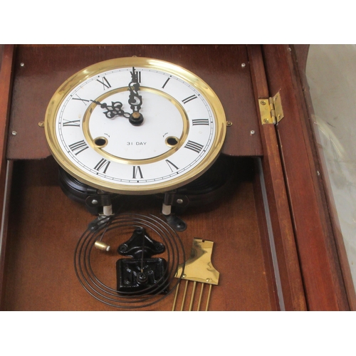 48 - A modern mahogany cased and glazed wall clock; the 31 day movement faced by a Roman dial  43