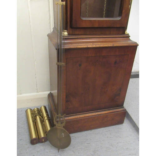 52 - A modern yewwood longcase clock; the movement faced by a Roman dial with (three weights and pendulum... 