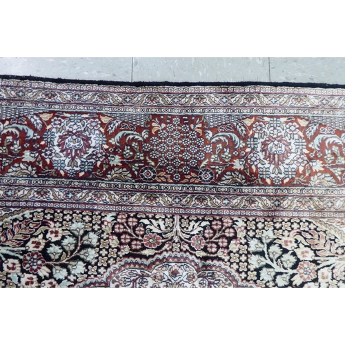 70 - A Persian woollen and silk rug, decorated with dense flora, on a gold and cream coloured ground  128... 