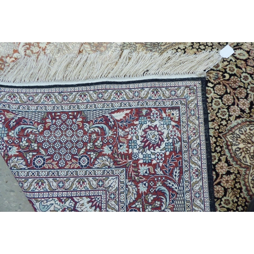 70 - A Persian woollen and silk rug, decorated with dense flora, on a gold and cream coloured ground  128... 