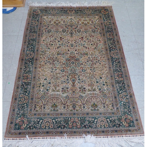 71 - A Persian silk rug, decorated with trees and birds, on a green and cream coloured ground  77