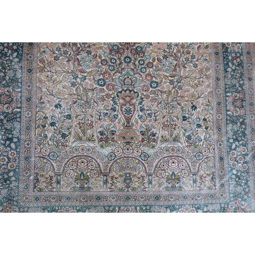 71 - A Persian silk rug, decorated with trees and birds, on a green and cream coloured ground  77