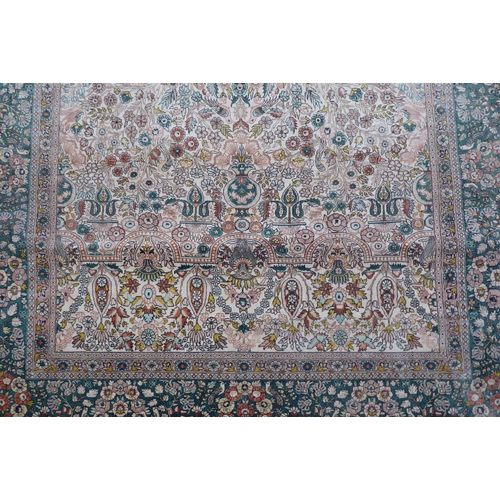 71 - A Persian silk rug, decorated with trees and birds, on a green and cream coloured ground  77