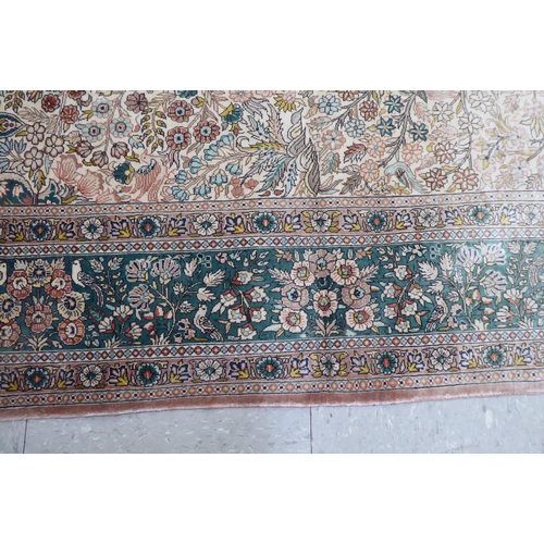 71 - A Persian silk rug, decorated with trees and birds, on a green and cream coloured ground  77