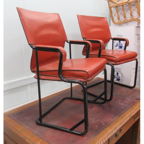 92 - A pair of Marcatre brown hide arm chairs, raised on black finished metal bases