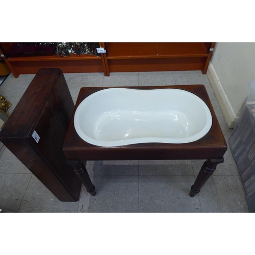 109 - A late Victorian mahogany bidet, having a removeable lid enclosing a ceramic liner, raised on turned... 