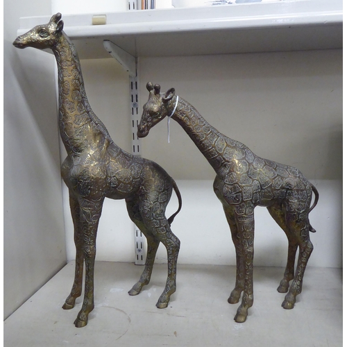 28 - Two similar African brass models, standing giraffes  23