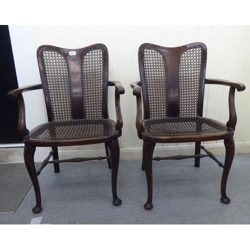 314 - A pair of 1930s stained beech framed bedroom chairs with caned backs and seats, raised on cabriole l... 