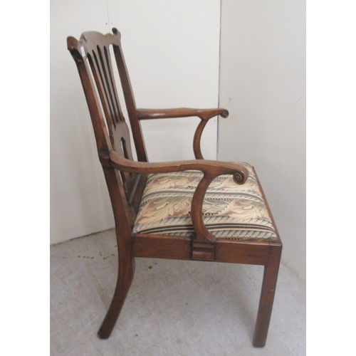 26 - A George III walnut framed, pierced splat back elbow chair, the drop-in seat raised on square forele... 