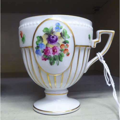 116 - A Herend porcelain pedestal cabinet cup and saucer, no.4985, decorated with flora and gilding