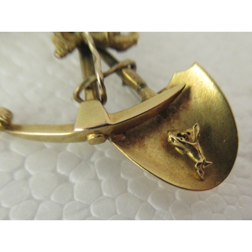 104 - A yellow metal gold prospector's brooch, fashioned as a shovel and pickaxe