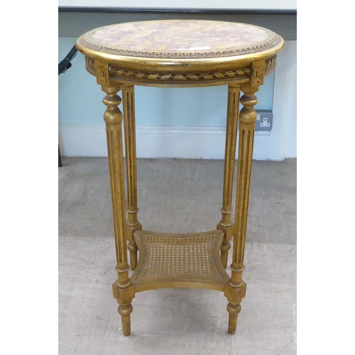 129 - A 20thC reproduction of a Continental giltwood centre table with an inset mottled marble top, over a... 