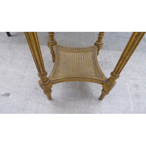 129 - A 20thC reproduction of a Continental giltwood centre table with an inset mottled marble top, over a... 