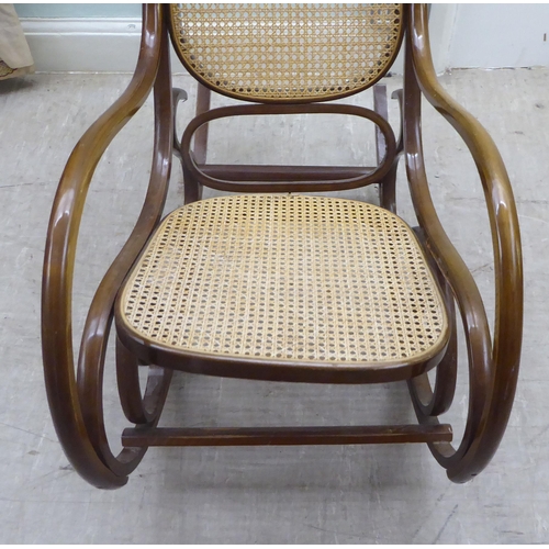 136 - A modern stained bentwood style woven cane panelled rocking chair