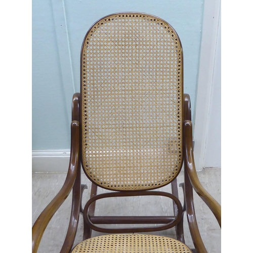 136 - A modern stained bentwood style woven cane panelled rocking chair