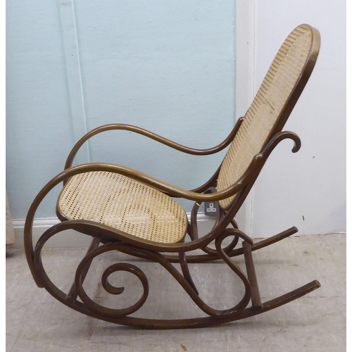 136 - A modern stained bentwood style woven cane panelled rocking chair