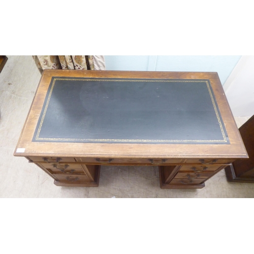 137 - An early 20thC oak nine drawer, twin pedestal desk, on a plinth and casters  30