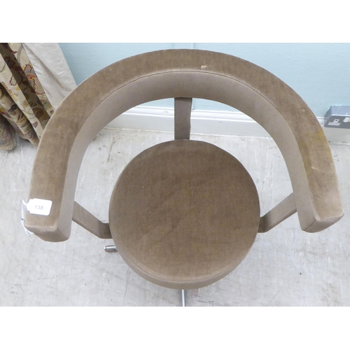 138 - A 1960s mushroom coloured dralon upholstered, low, round back swivel chair, rotating on a splayed qu... 