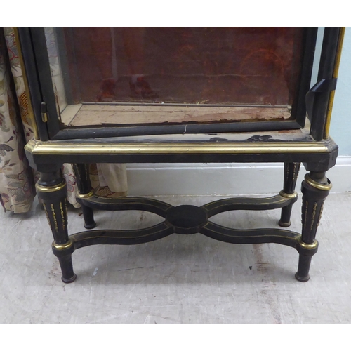 139 - A late 19thC French Empire style display cabinet, partially glazed with black and gilt trim, raised ... 