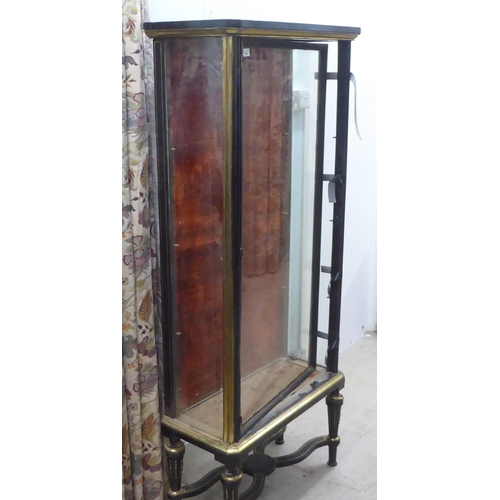 139 - A late 19thC French Empire style display cabinet, partially glazed with black and gilt trim, raised ... 