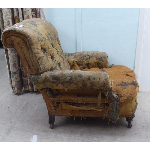 140 - A late 19thC armchair, in the manner of Howard, with a scrolled, part button upholstered back (in ne... 