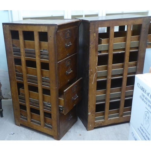 145 - A pair of 1920s oak four drawer filing cabinets, on a plinth  53