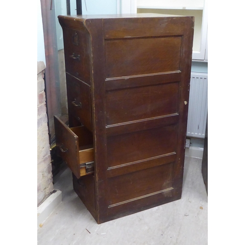 145 - A pair of 1920s oak four drawer filing cabinets, on a plinth  53