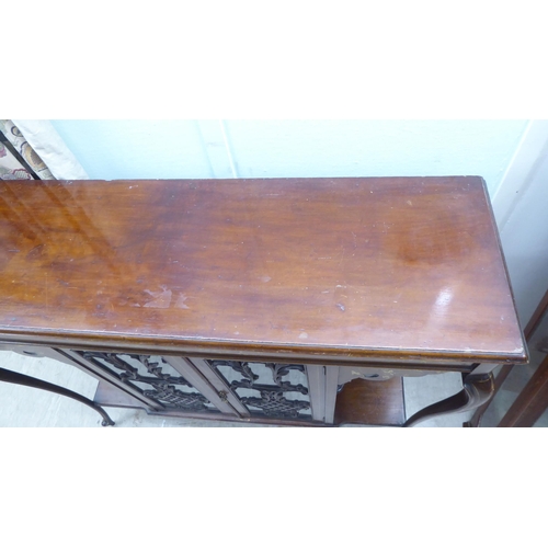 155 - An Edwardian mahogany sideboard with a pair of central glazed doors, flanked by open sections, raise... 