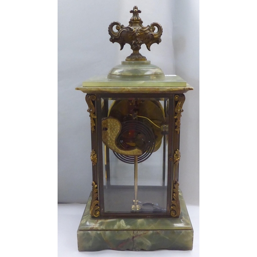 161 - An early 20thC onyx and brass framed, four glass mantel timepiece; the movement faced by a Roman dia... 