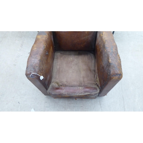 182 - An Art Deco fireside chair frame, raised on block feet