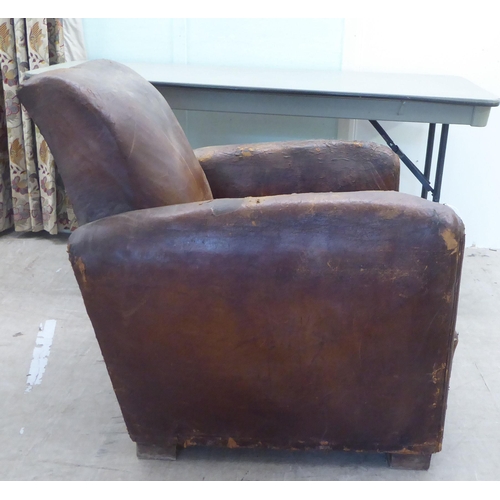 182 - An Art Deco fireside chair frame, raised on block feet