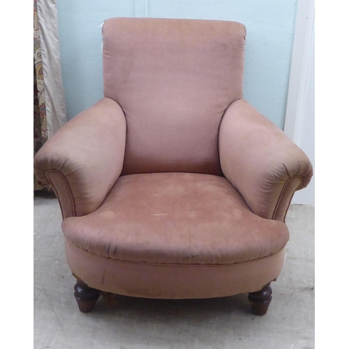 195 - A late Victorian fabric upholstered, low enclosed armchair, raised on turned forelegs 