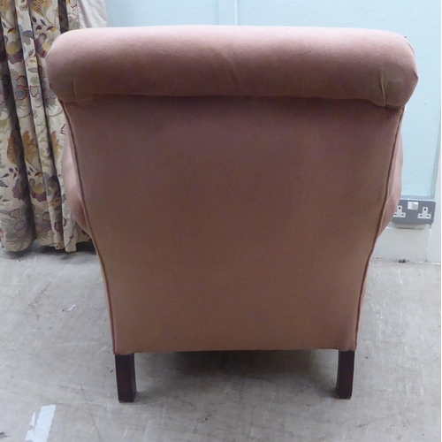 195 - A late Victorian fabric upholstered, low enclosed armchair, raised on turned forelegs 