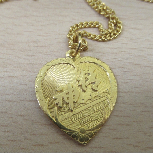 20 - A Chinese 22ct gold curb link chain and a heart shaped pendant, embossed with flowers