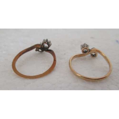 21 - An 18ct gold two stone, claw set diamond crossover ring; and another similar, but with one loose sto... 