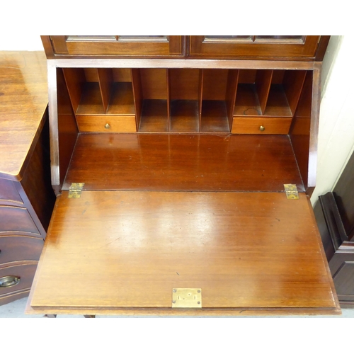 239 - An Arts & Crafts string inlaid mahogany bureau bookcase with a pair of glazed doors, over a fall... 