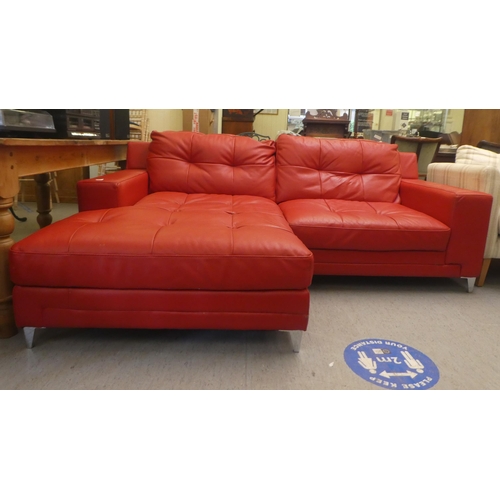 320 - A modern two part corner settee, upholstered in stitched red hide, raised on metal peg feet  65