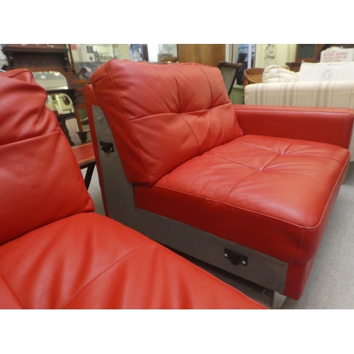 320 - A modern two part corner settee, upholstered in stitched red hide, raised on metal peg feet  65