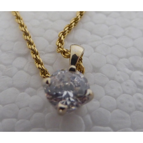 403 - A claw set cubic zirconia pendant, on a fine twist link, gold coloured metal chain  stamped 750... 