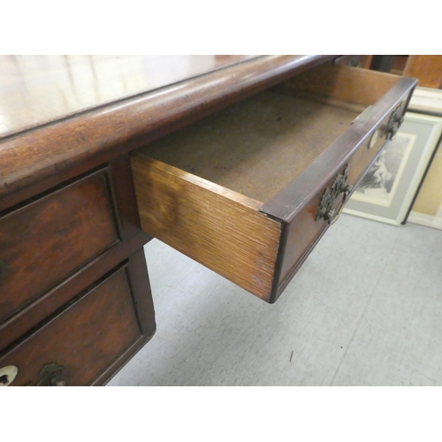 409 - A late Georgian mahogany kneehole desk, comprising five drawers with cockbeading and brass bail hand... 