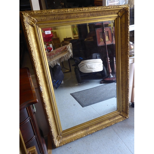 412 - A Victorian style bevelled mirror, set in a decoratively moulded gilt frame  43