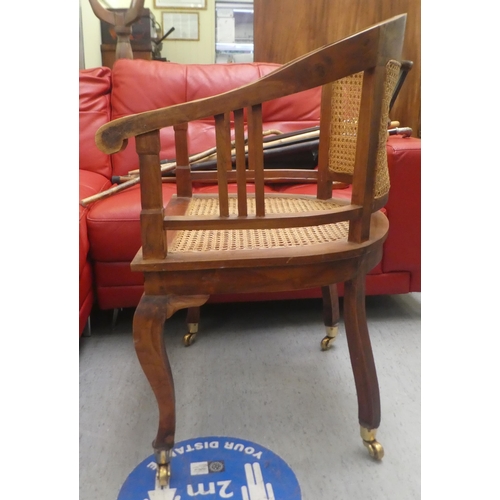 417 - A Colonial style hardwood framed, round back desk chair with scrolled arms, the woven split cane sea... 