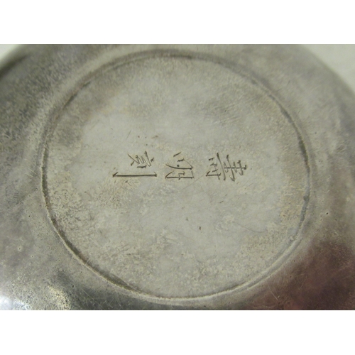 42 - An Oriental white metal circular tablet box, the cover cast with a dragon and inscribed on the under... 